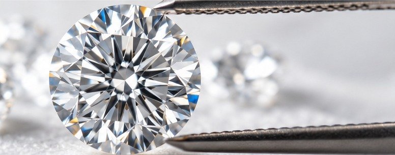 Close-up of a loose round brilliant diamond held with jeweler's tweezers